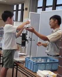 ろ過機に水を入れて水をきれいにするための実験を行う様子